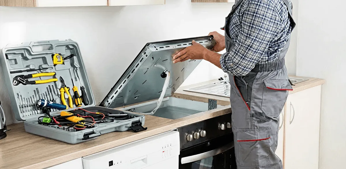 Handyman repairing a cooktop and checking wiring connections in Marietta, GA